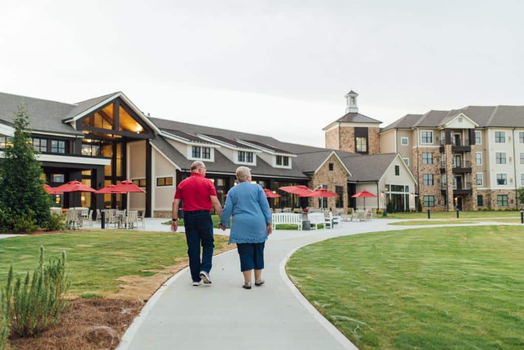 Resident couple walking outdoors in front of the courtyard